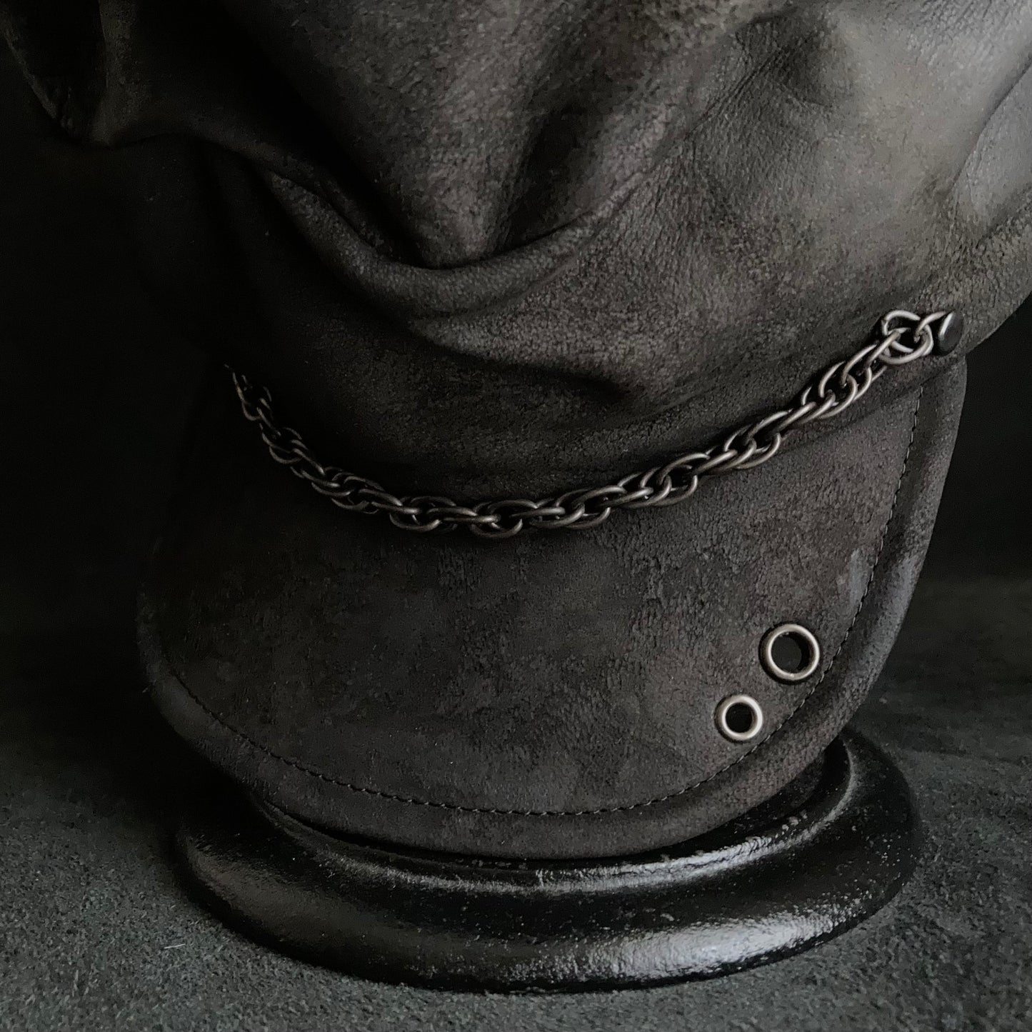 Rubbed black leather chain turn cap