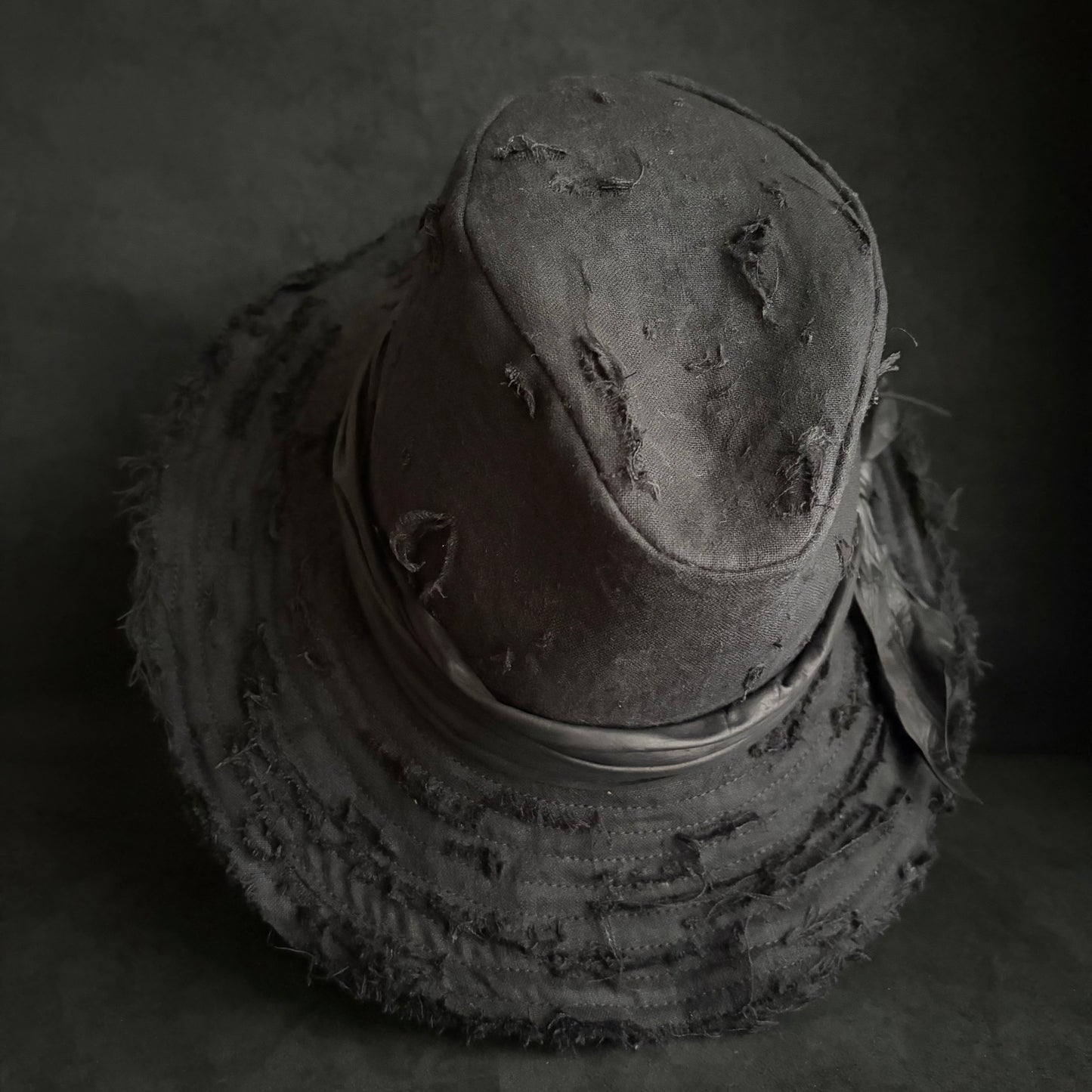 Black linen damage around fedora hat