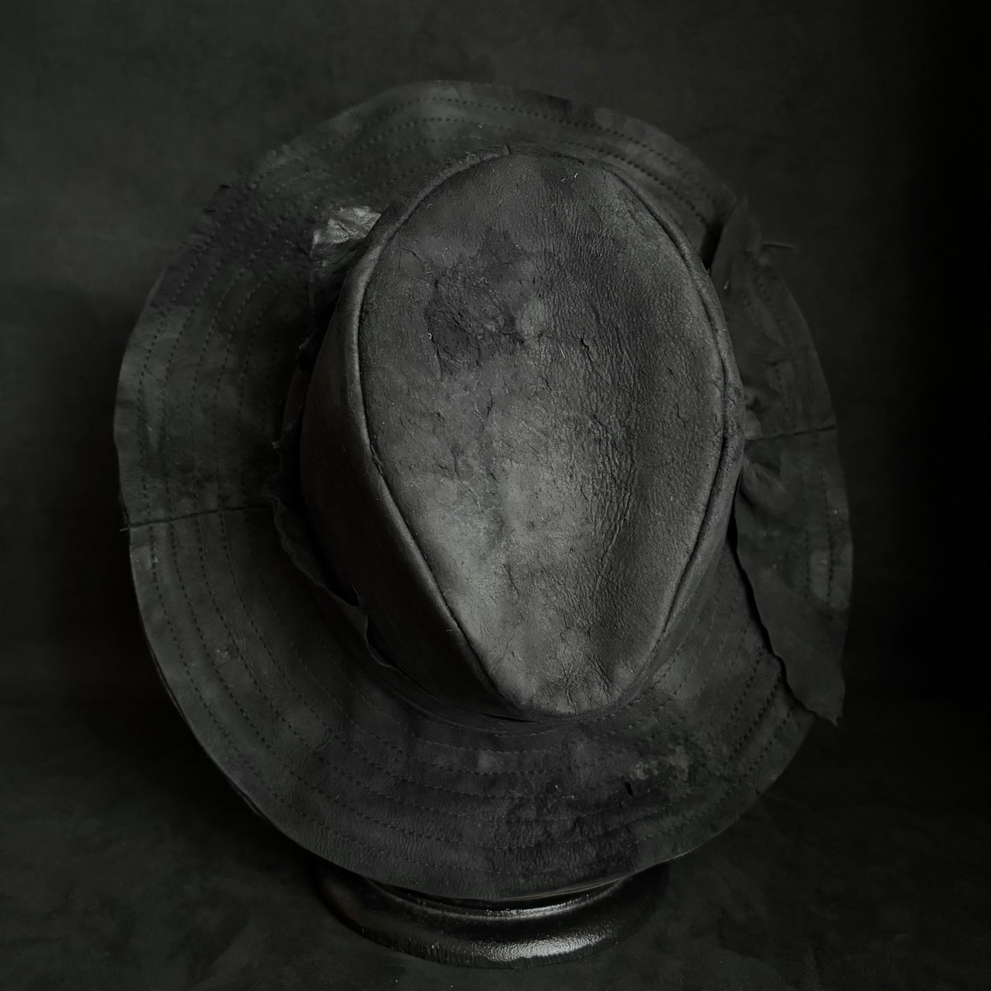 Faded black leather fedora hat