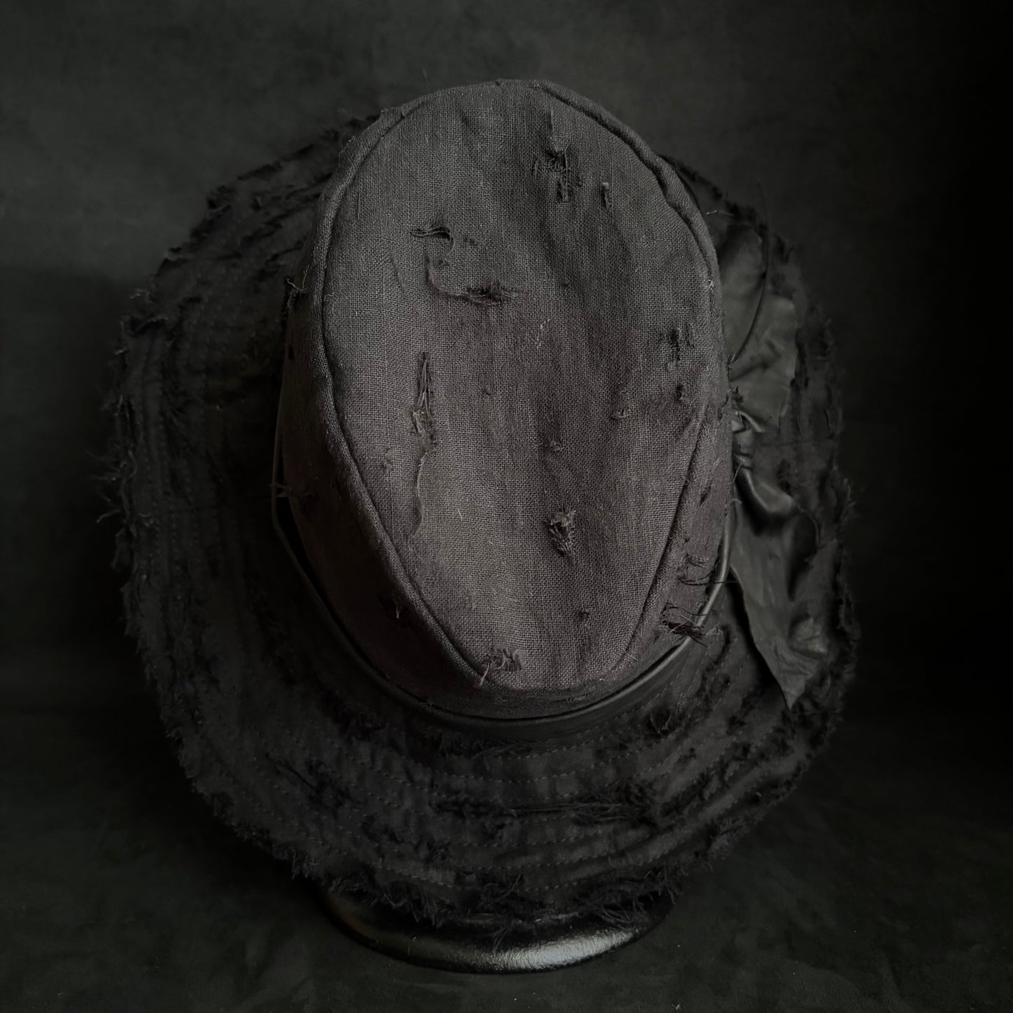 Black linen damage around fedora hat