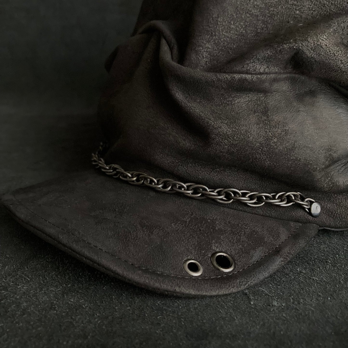 Rubbed black leather chain turn cap