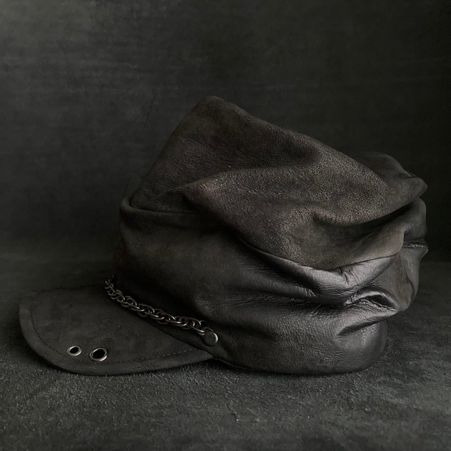 Rubbed black leather chain turn cap