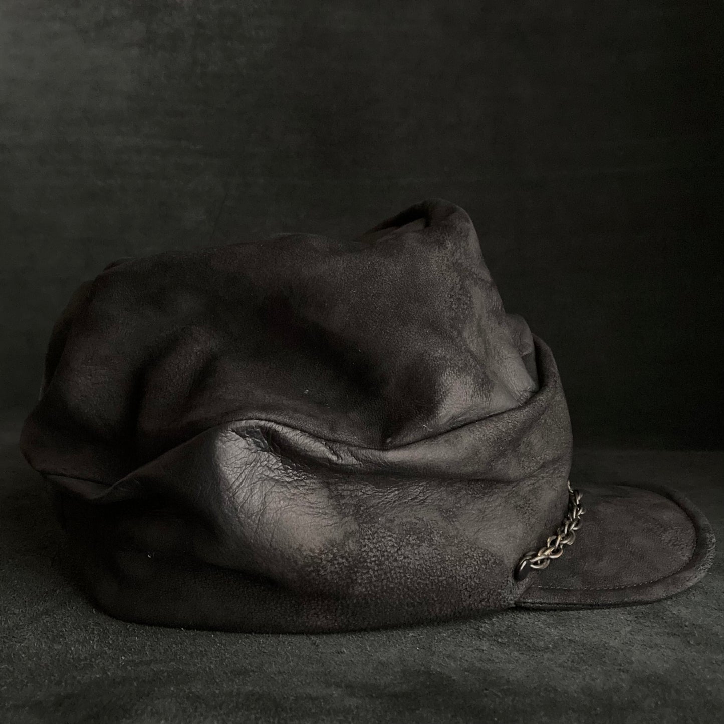 Rubbed black leather chain turn cap