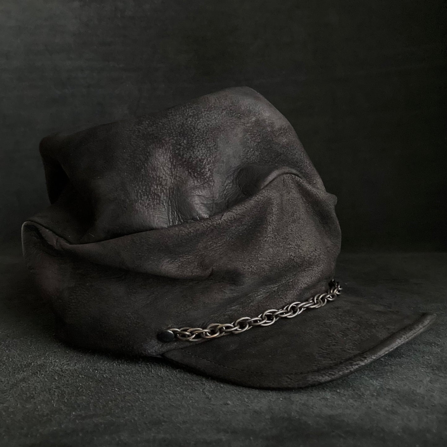 Rubbed black leather chain turn cap