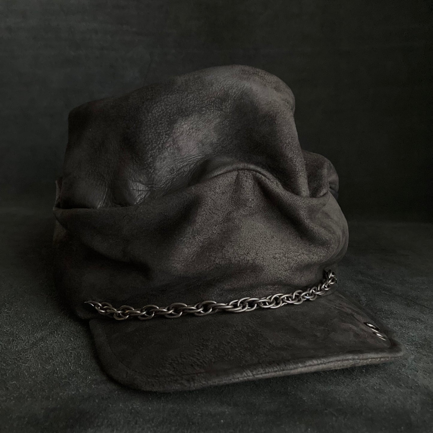 Rubbed black leather chain turn cap