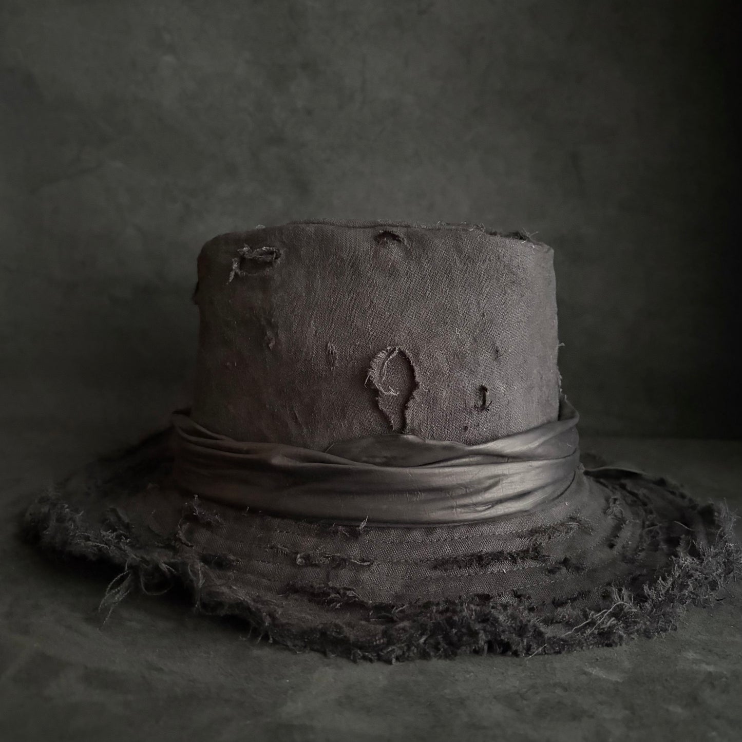 Black linen damage around fedora hat