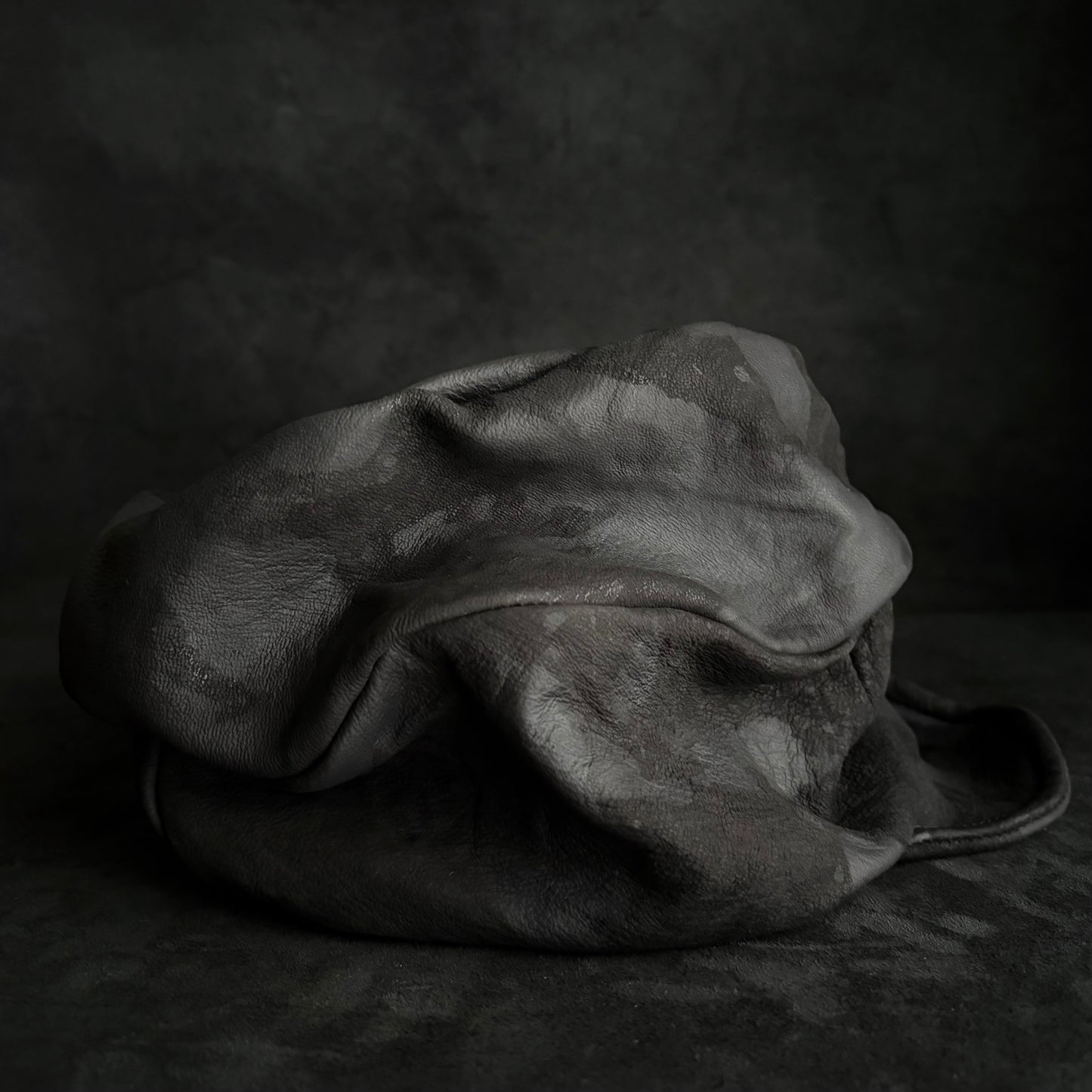 Bleached stable black leather turn cap