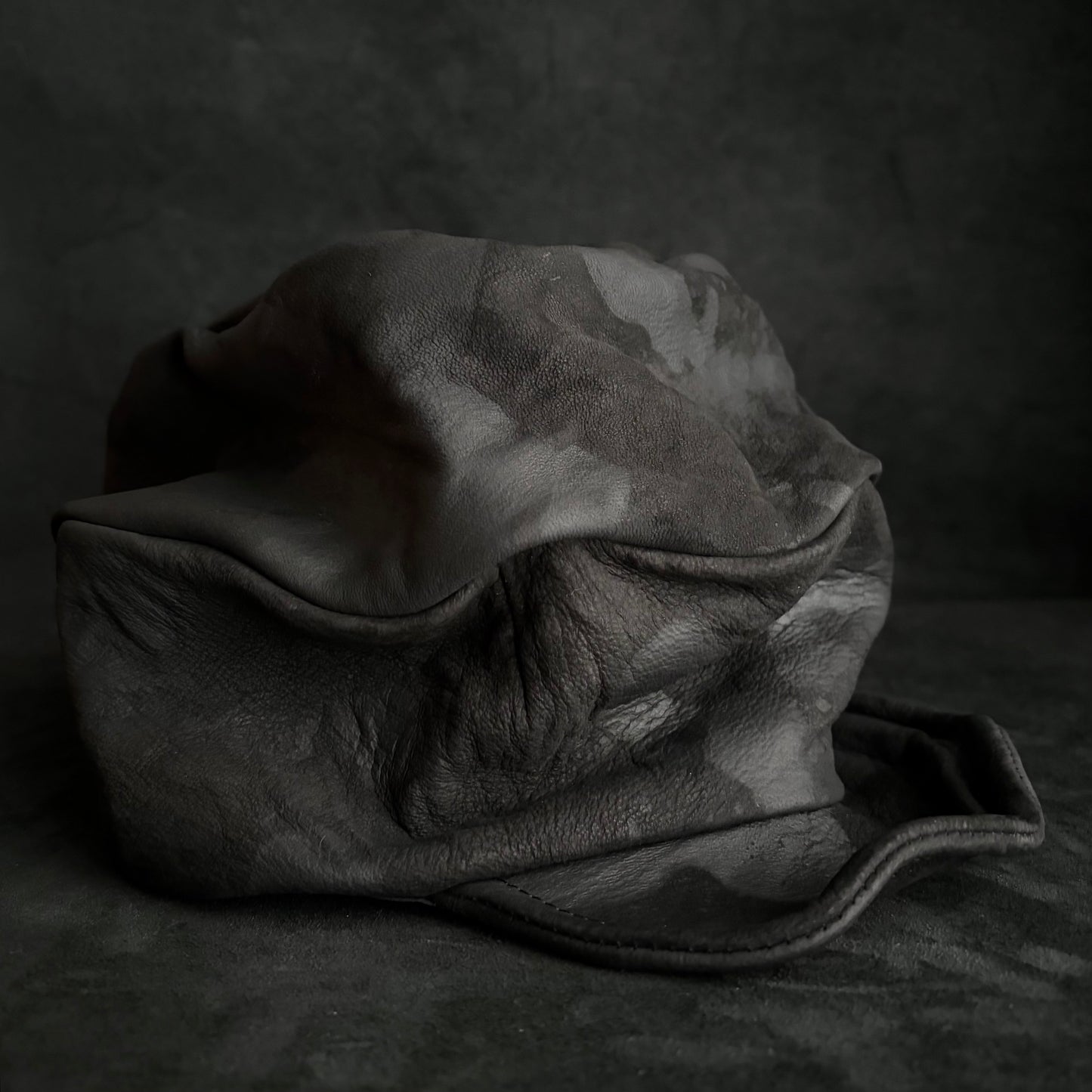 Bleached stable black leather turn cap