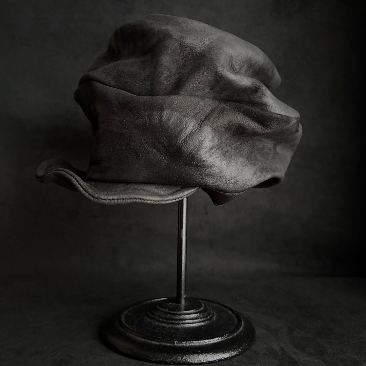 Bleached stable black leather turn cap