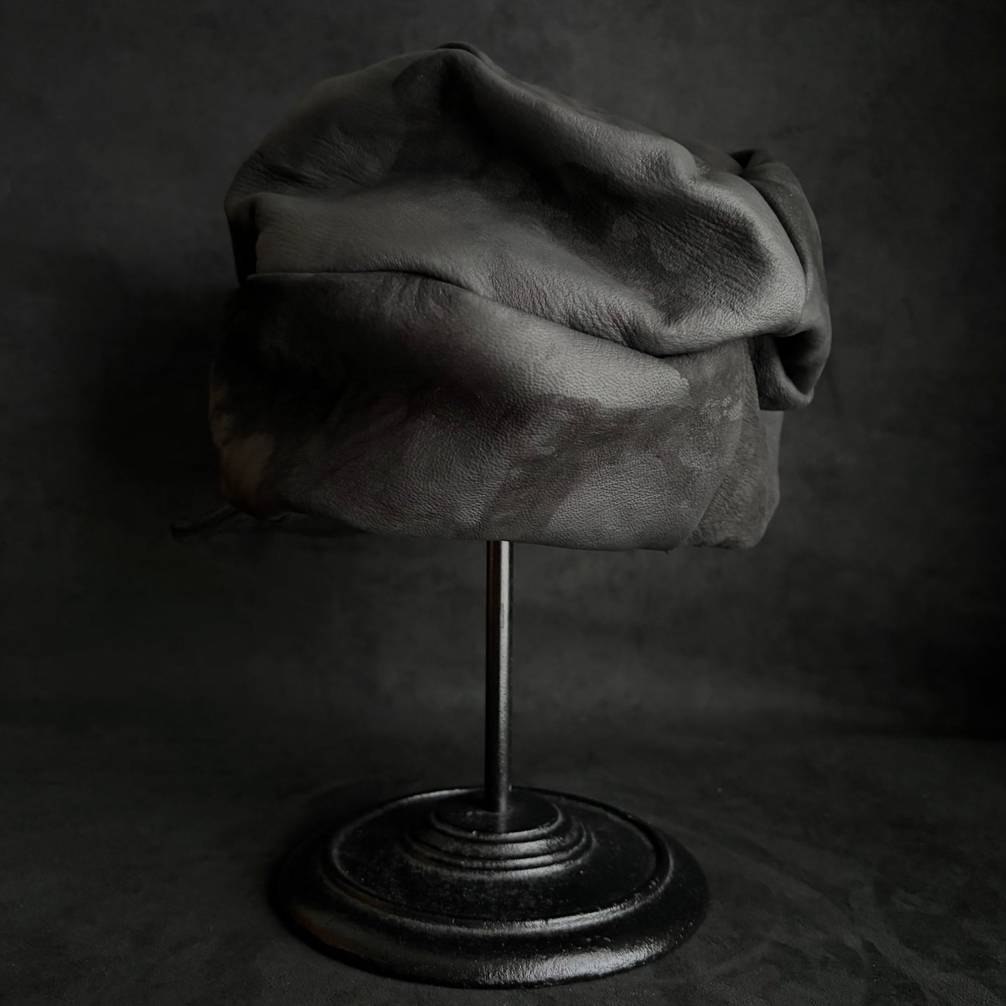 Bleached stable black leather turn cap
