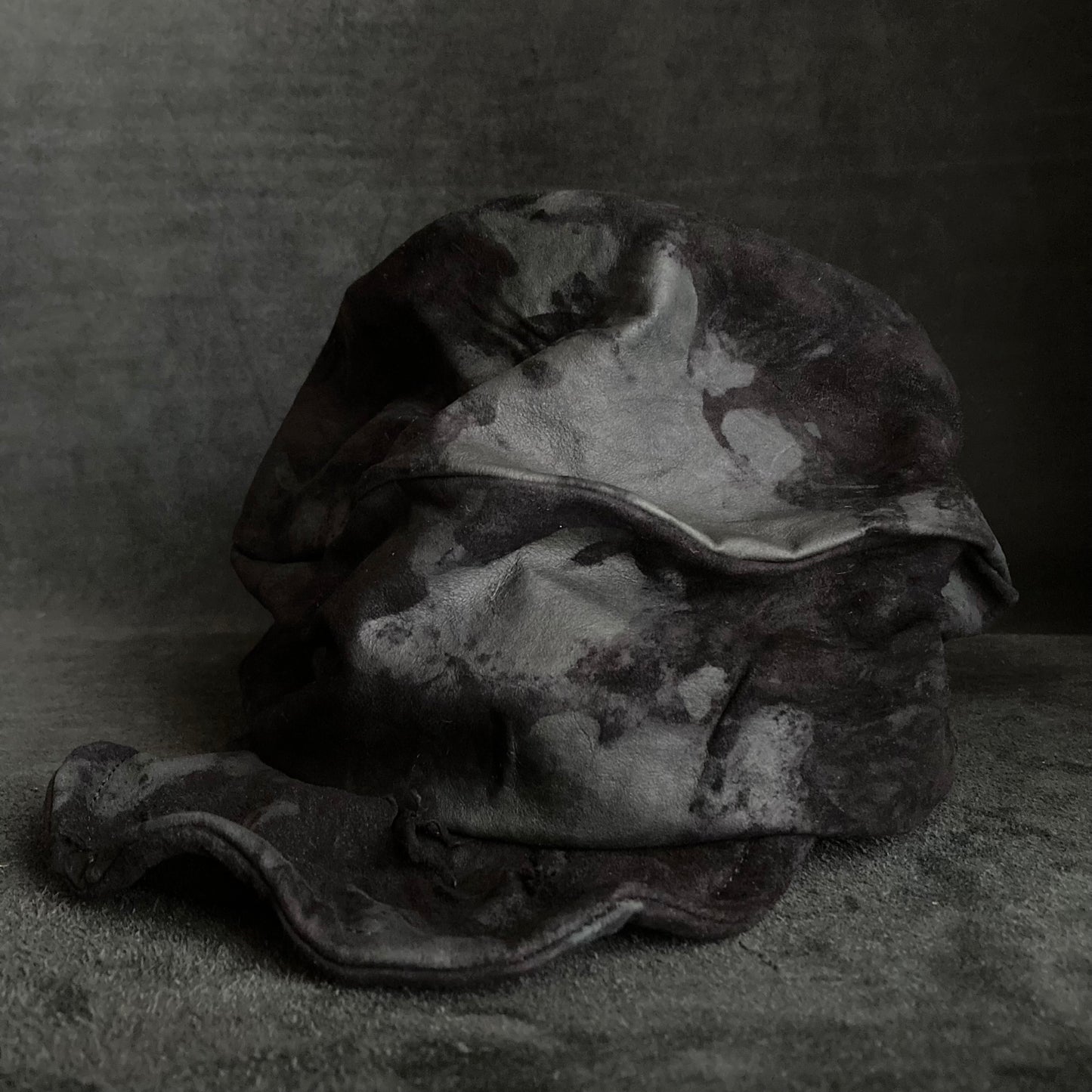 Bleached black leather turn cap