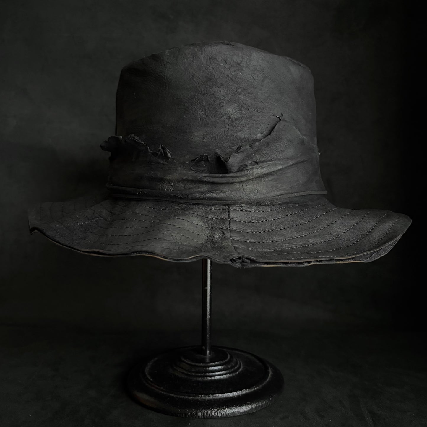 Faded black leather fedora hat