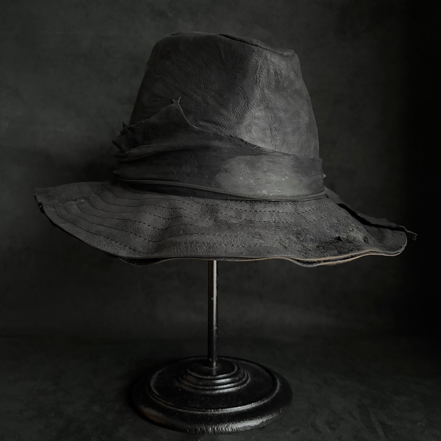 Faded black leather fedora hat