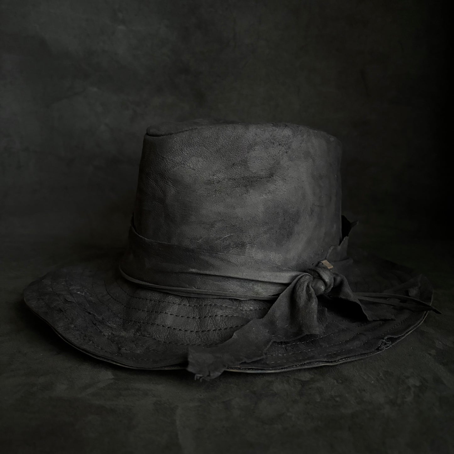 Faded black leather fedora hat