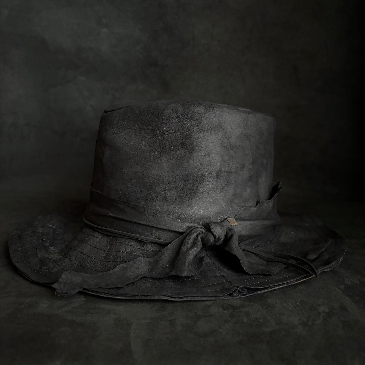 Faded black leather fedora hat