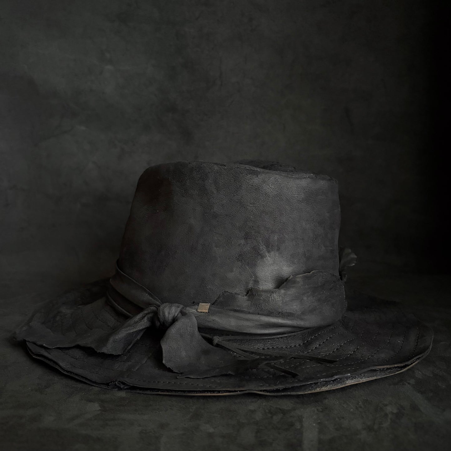 Faded black leather fedora hat