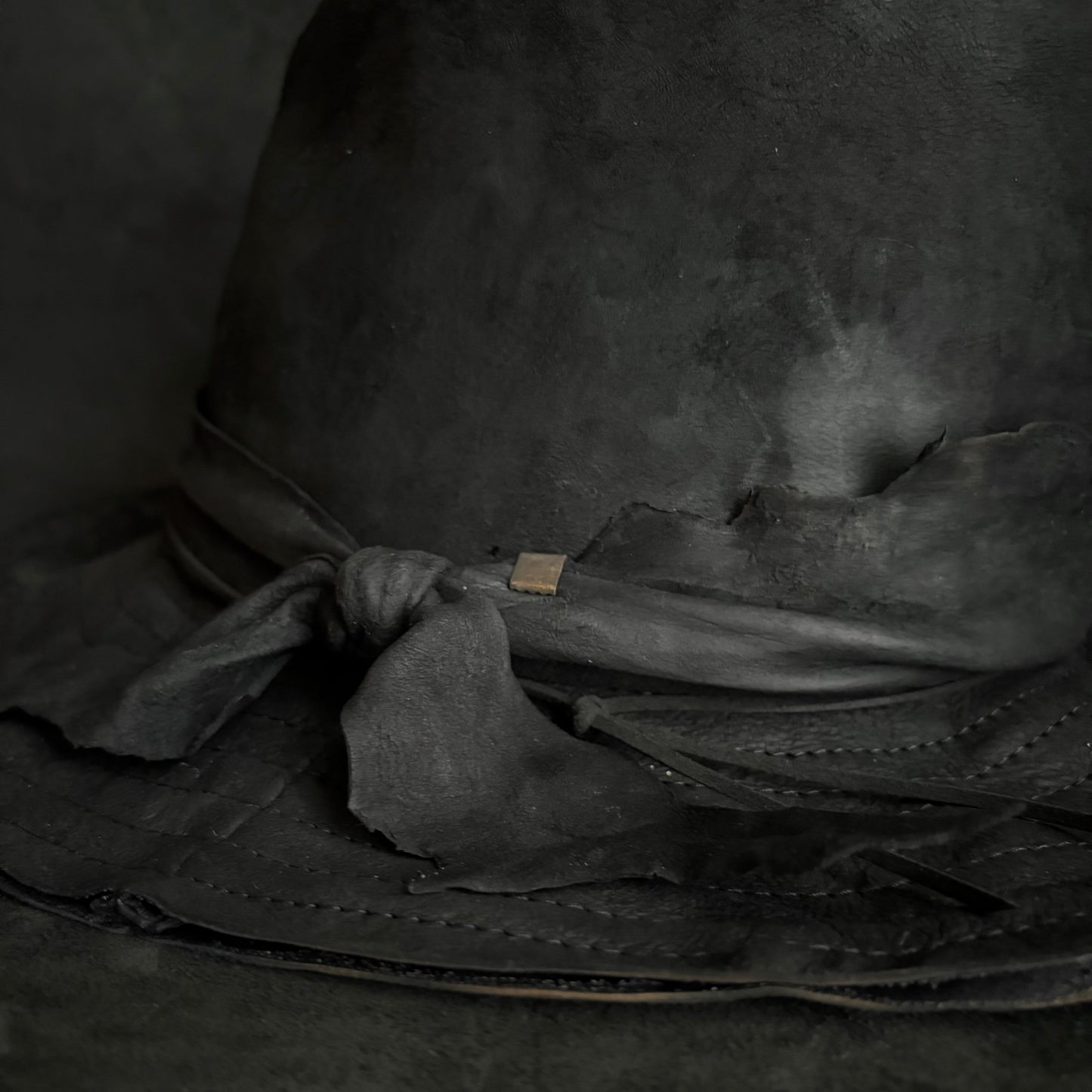 Faded black leather fedora hat
