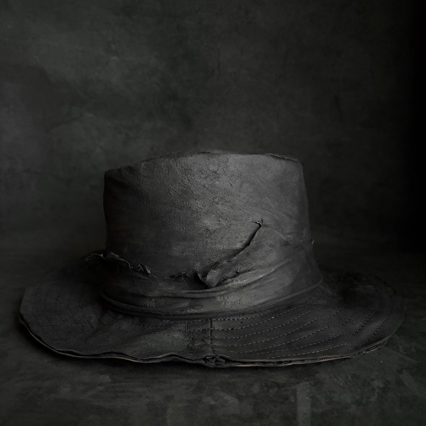 Faded black leather fedora hat