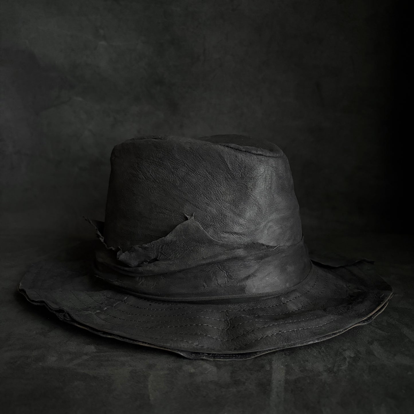 Faded black leather fedora hat