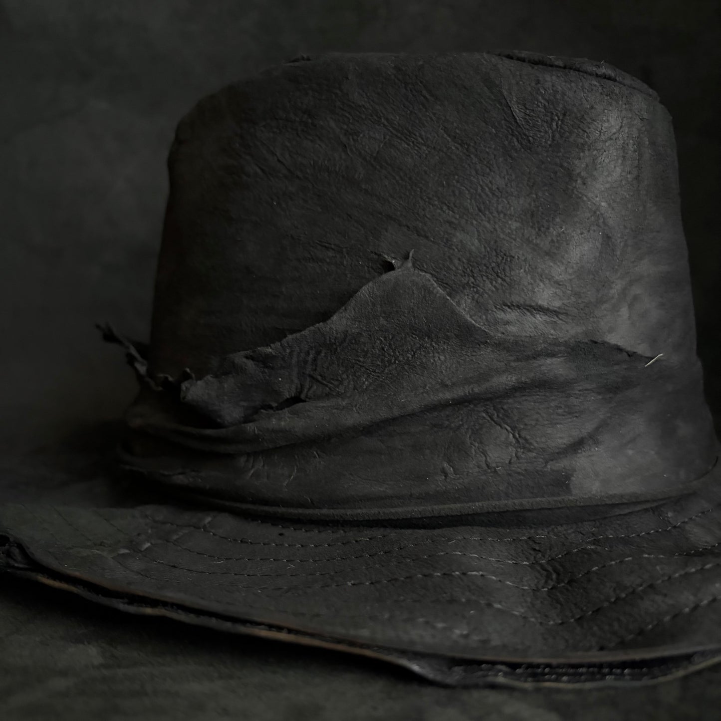 Faded black leather fedora hat
